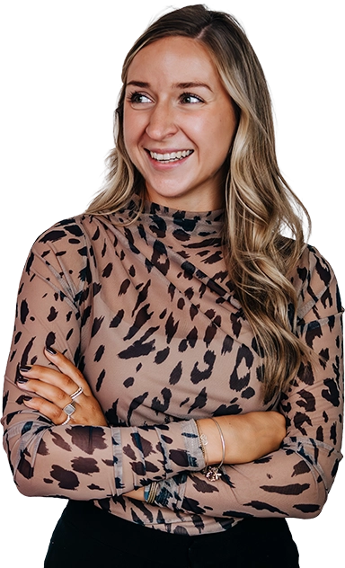 Frau in schwarz beigen Oberteil mit verschränkten Armen.