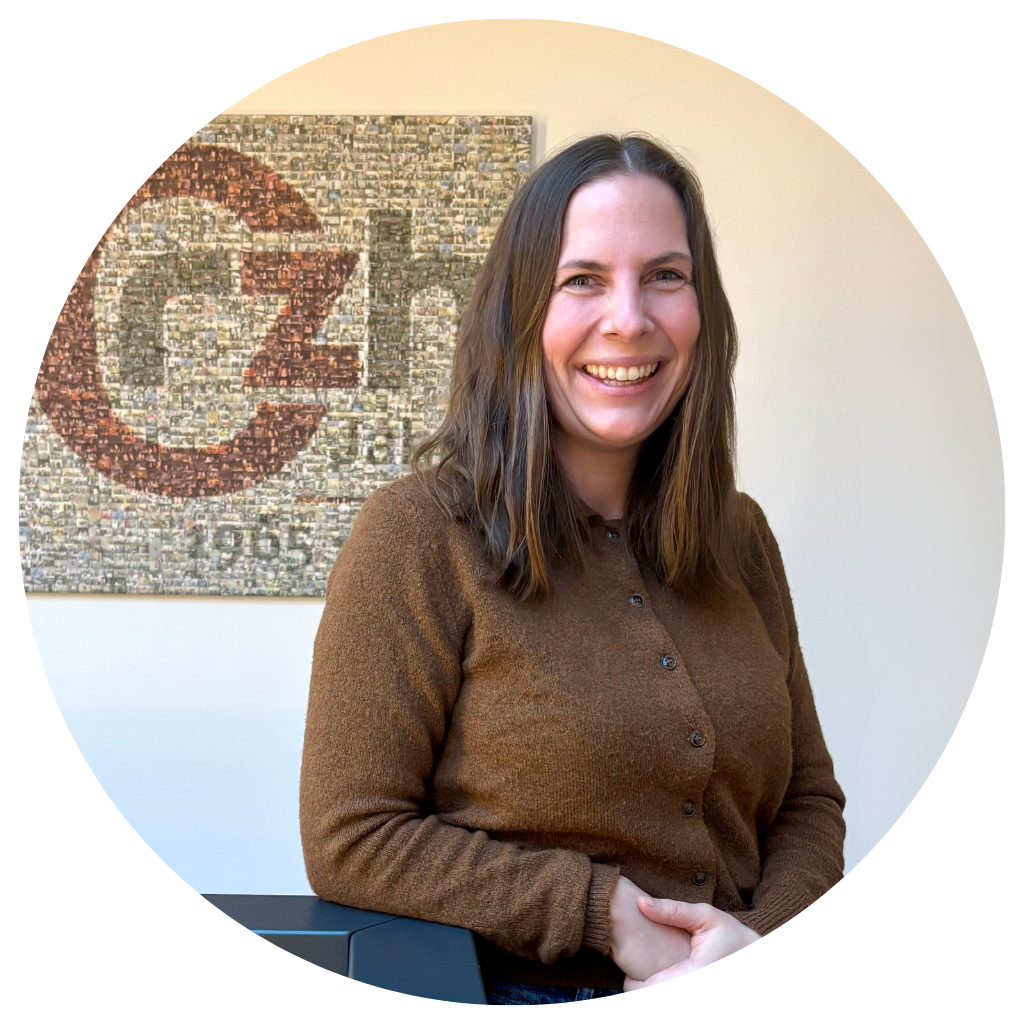 Portraitfoto von einer jungen Frau mit braunen Haaren und braunem Oberteil.